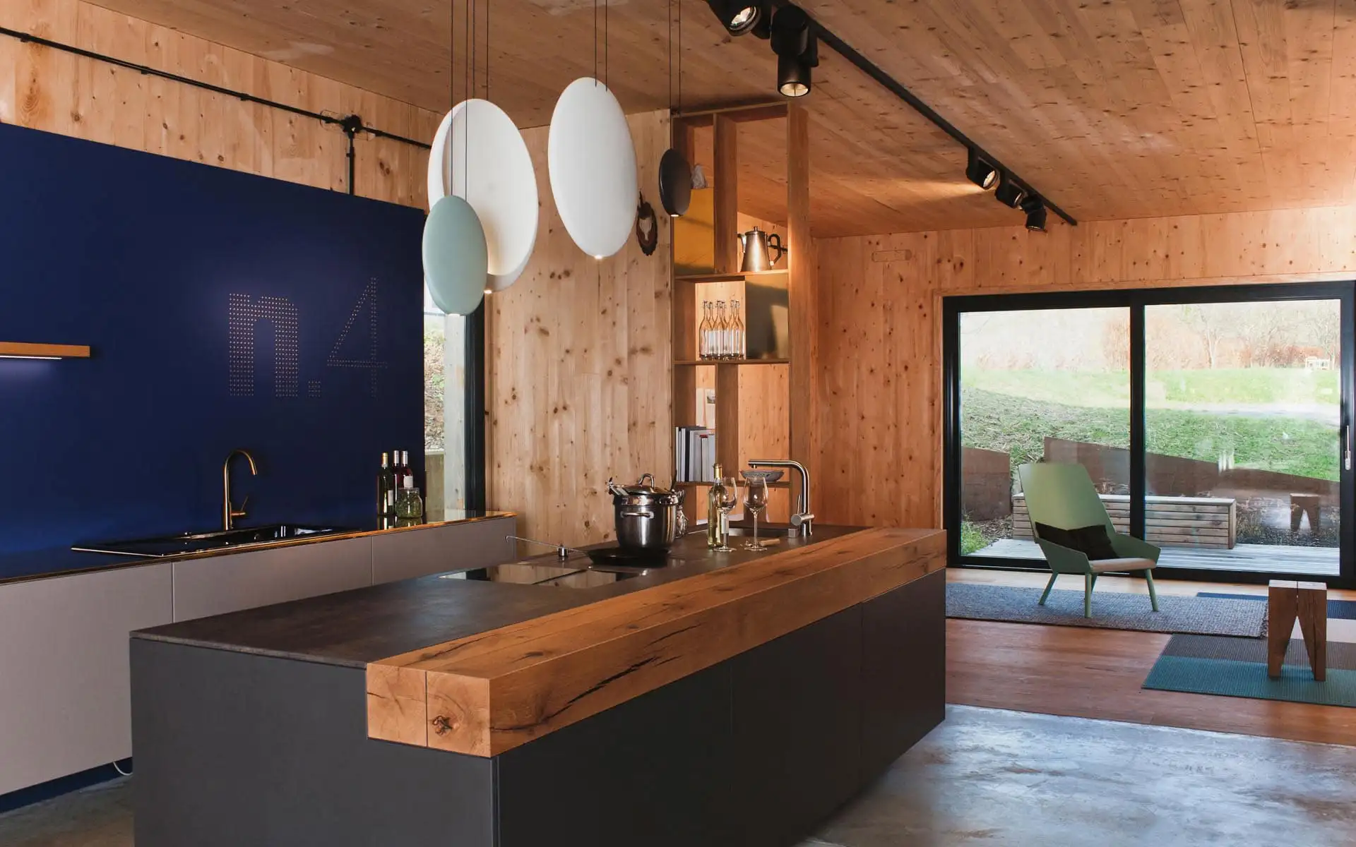 Detailansicht einer Kücheninsel mit Holzauflage, Spüle und Armatur in einem modern gestalteten Innenraum.