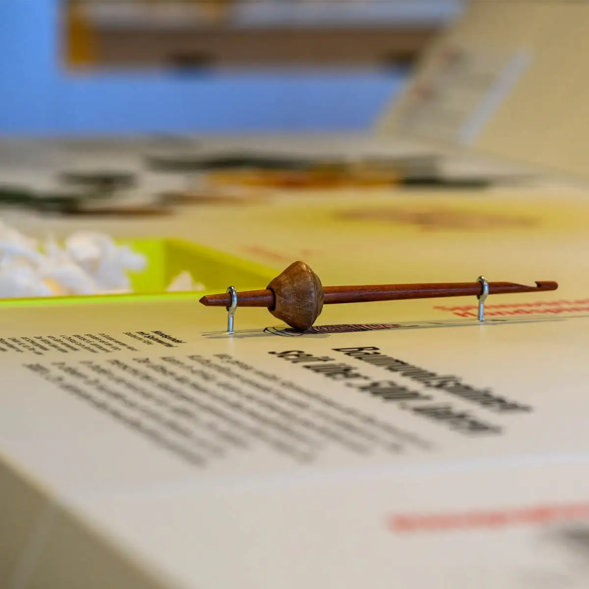 Historische Handspindel auf einer Ausstellungstafel