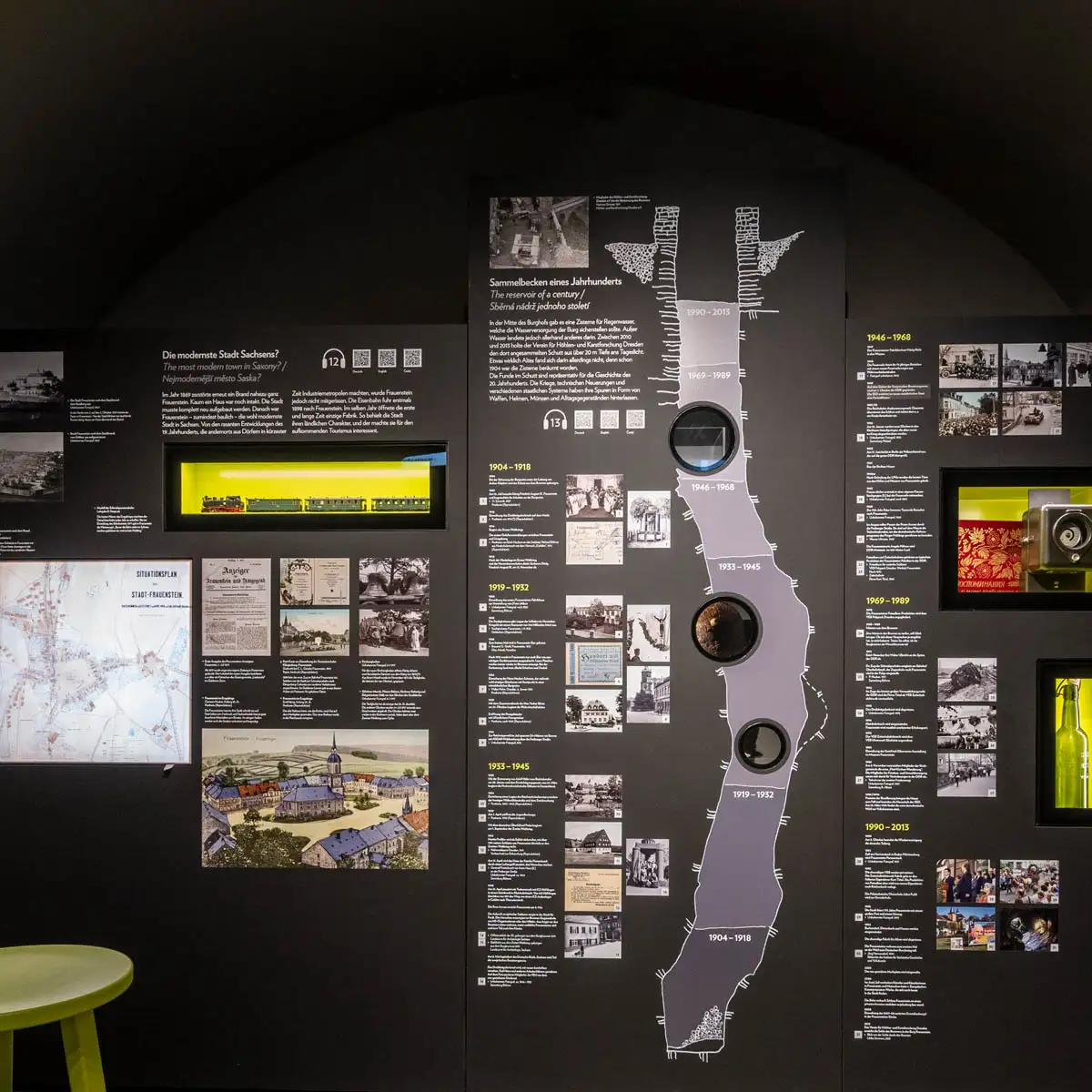 Wandgrafik zum Stammbaum der Familie Silbermann; Besucher scannt QR-Codes an Porträts.