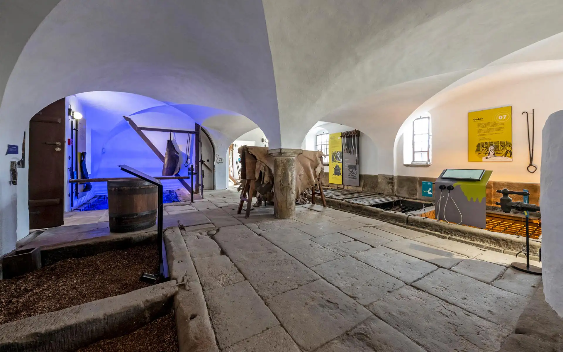 Gewölbekeller mit Stationen mit blau beleuchtetem Arbeitsbereich