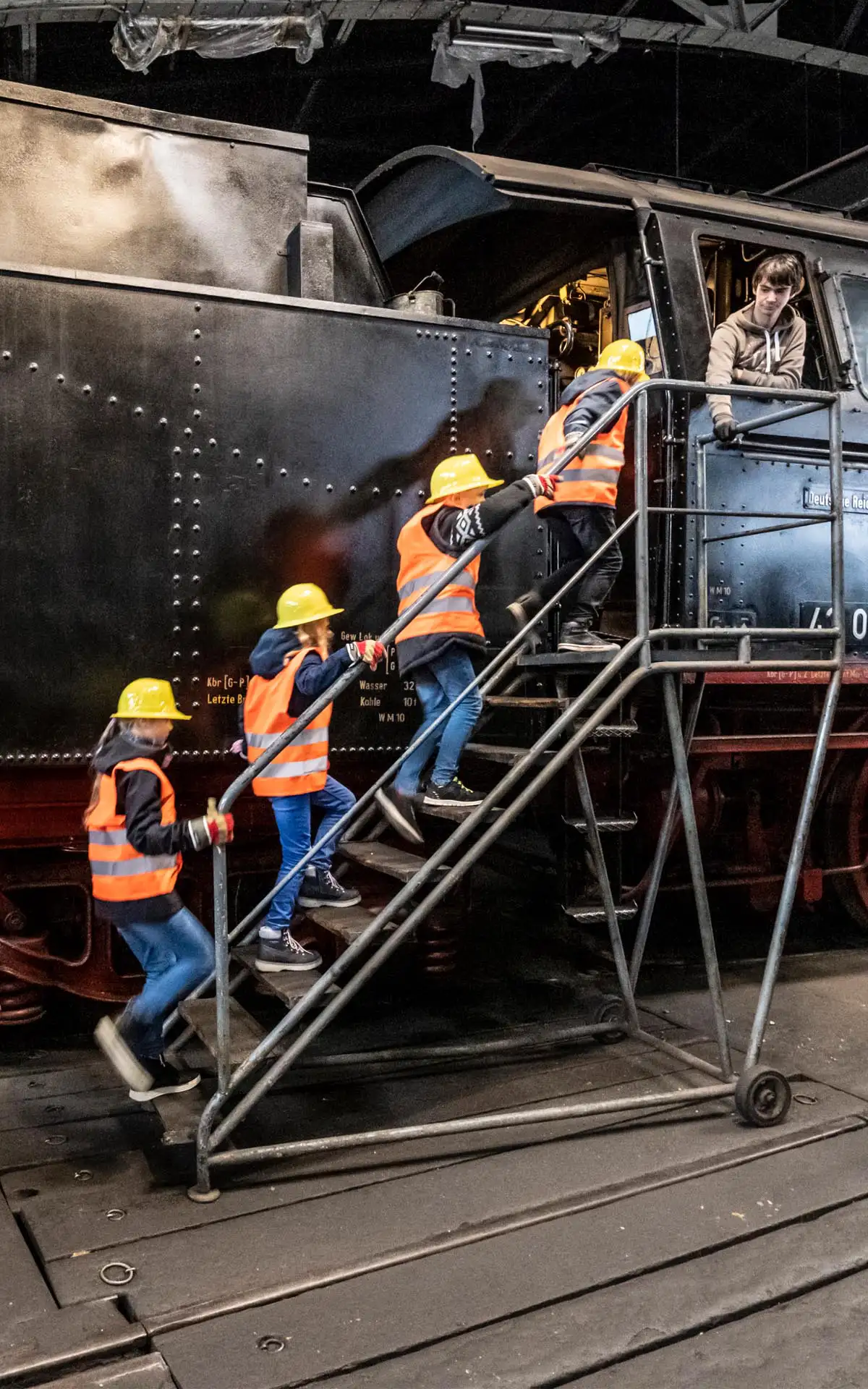 Gleisanlage im Freien mit Besuchern und bewachsenem Umfeld