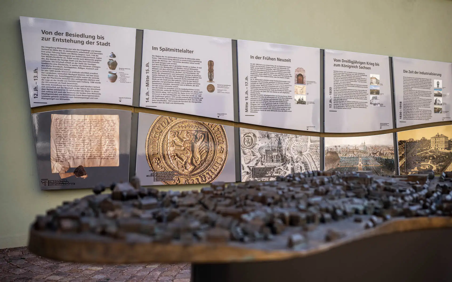 Historische Ausstellung in Mittweida mit Infotafeln zu Stadtentwicklung und großem taktilem Stadtmodell.