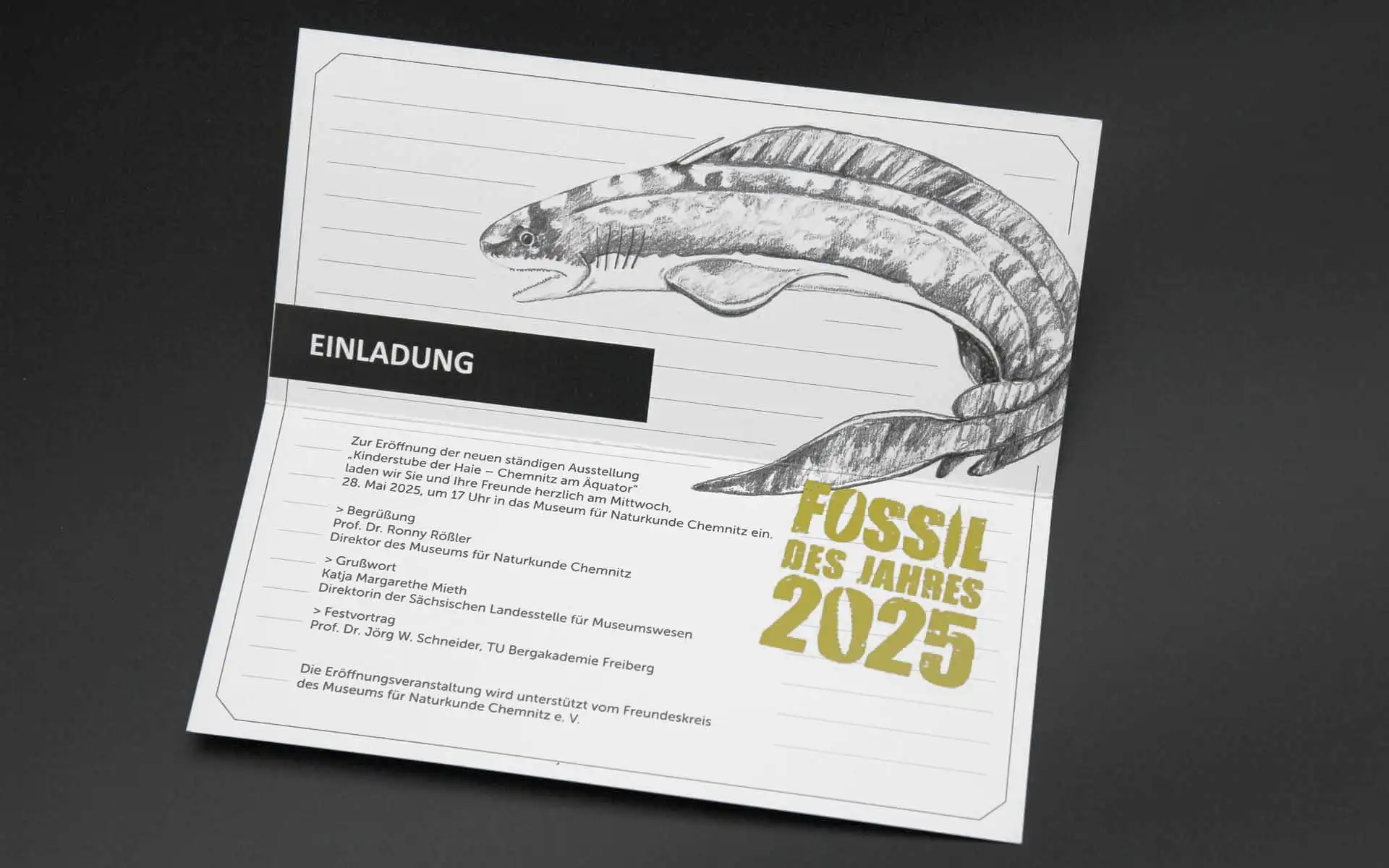 Einladung mit gezeichneter Fischdarstellung und Textblock, ergänzt durch den Schriftzug „Fossil des Jahres 2025“.