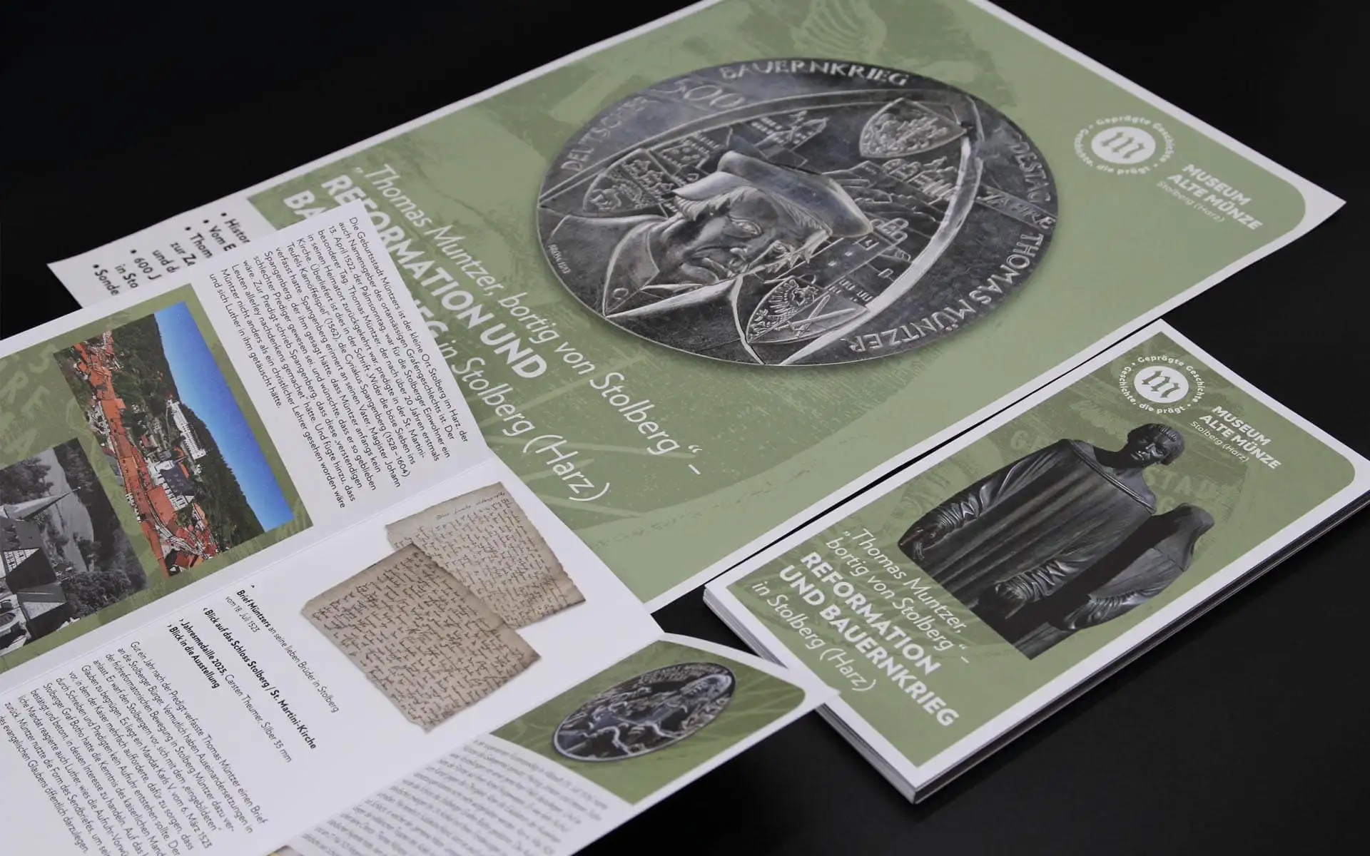 Mehrere Printmedien zum Thema „Reformation und Bauernkrieg“ mit grünem Layout, Bildmotiven und Broschürenstapel.