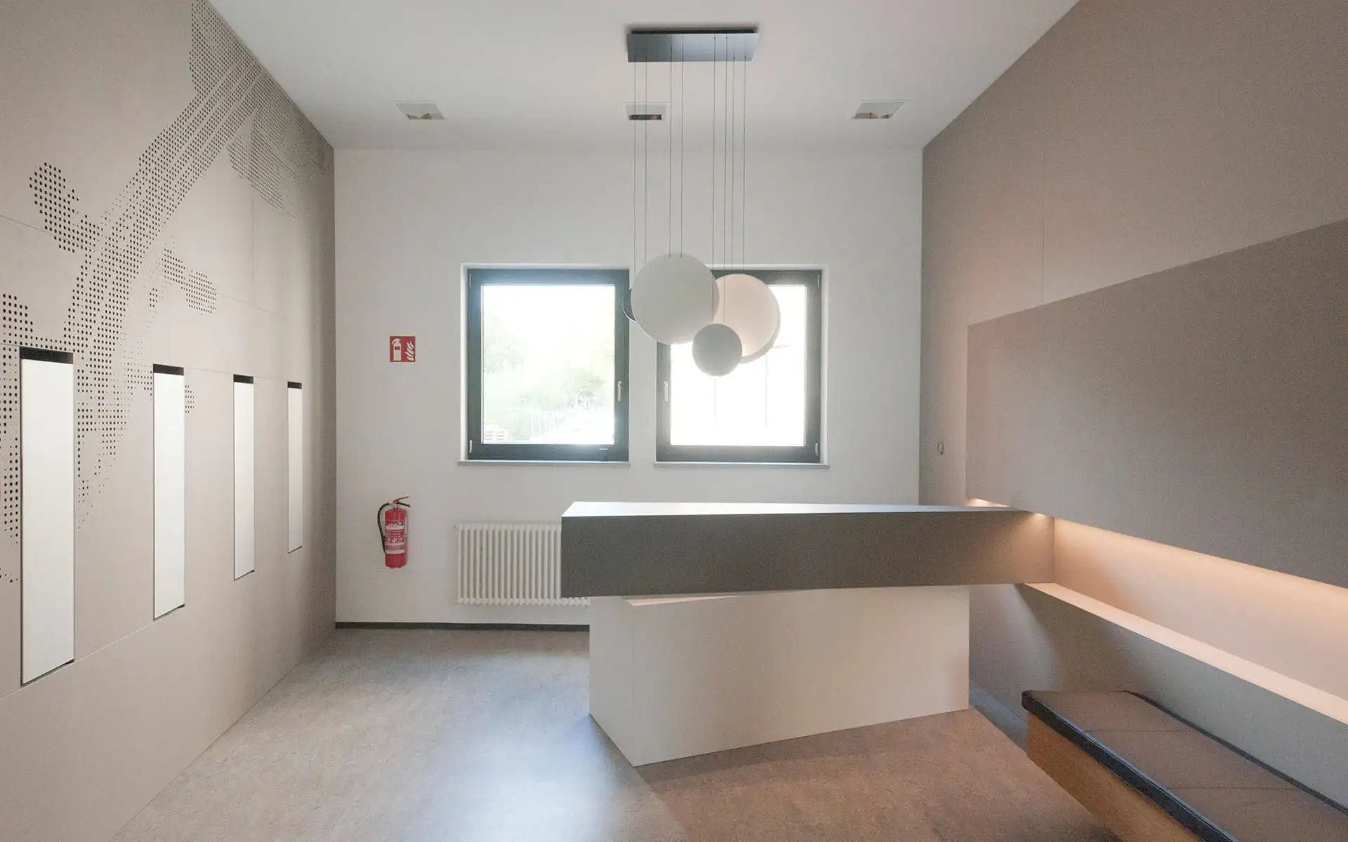 Foyer der Musikschule Chemnitz: schwebender Tresen, Sitznische und runde Pendelleuchten.