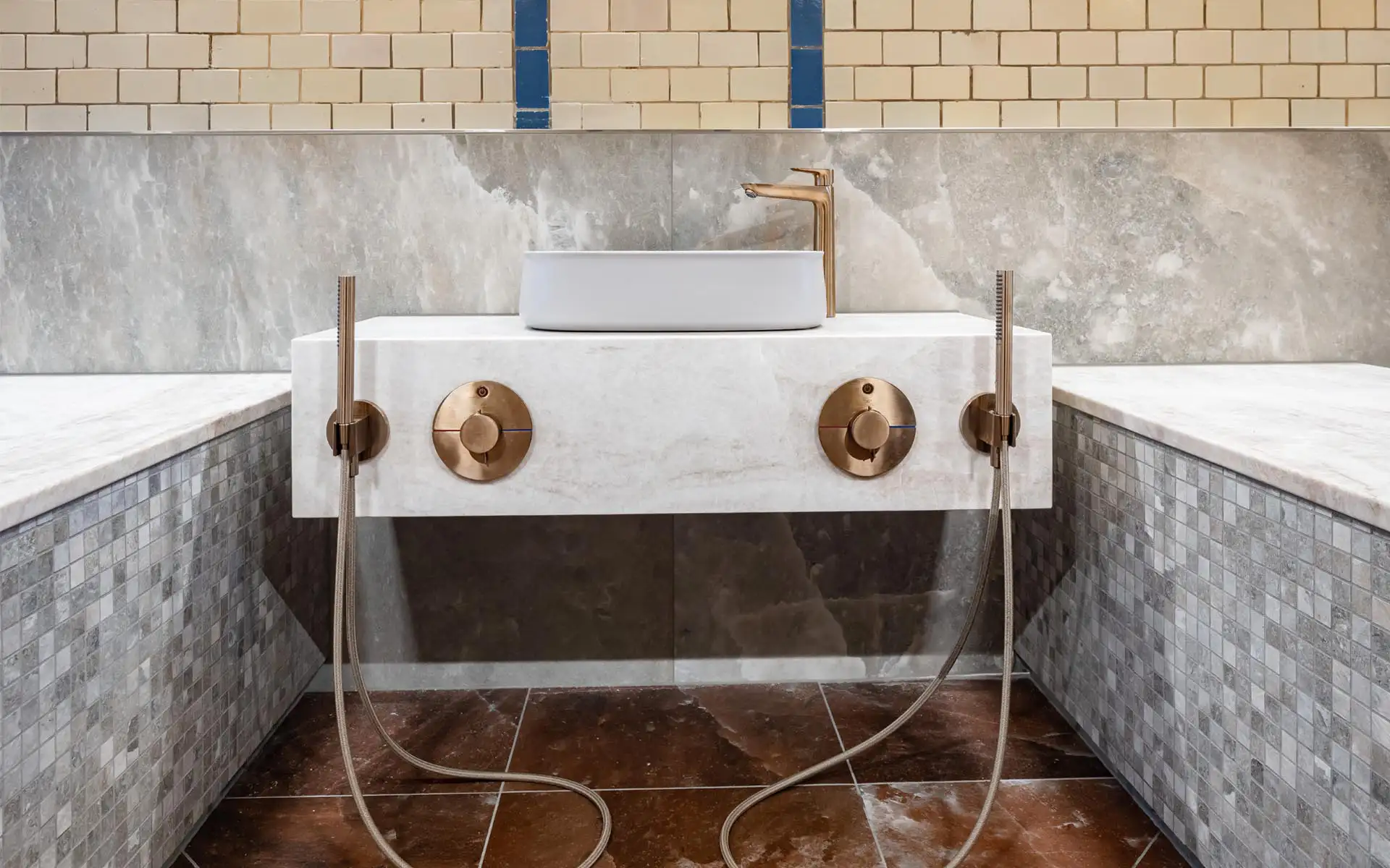 Nahaufnahme einer Marmorwaschtischanlage mit goldfarbenen Armaturen