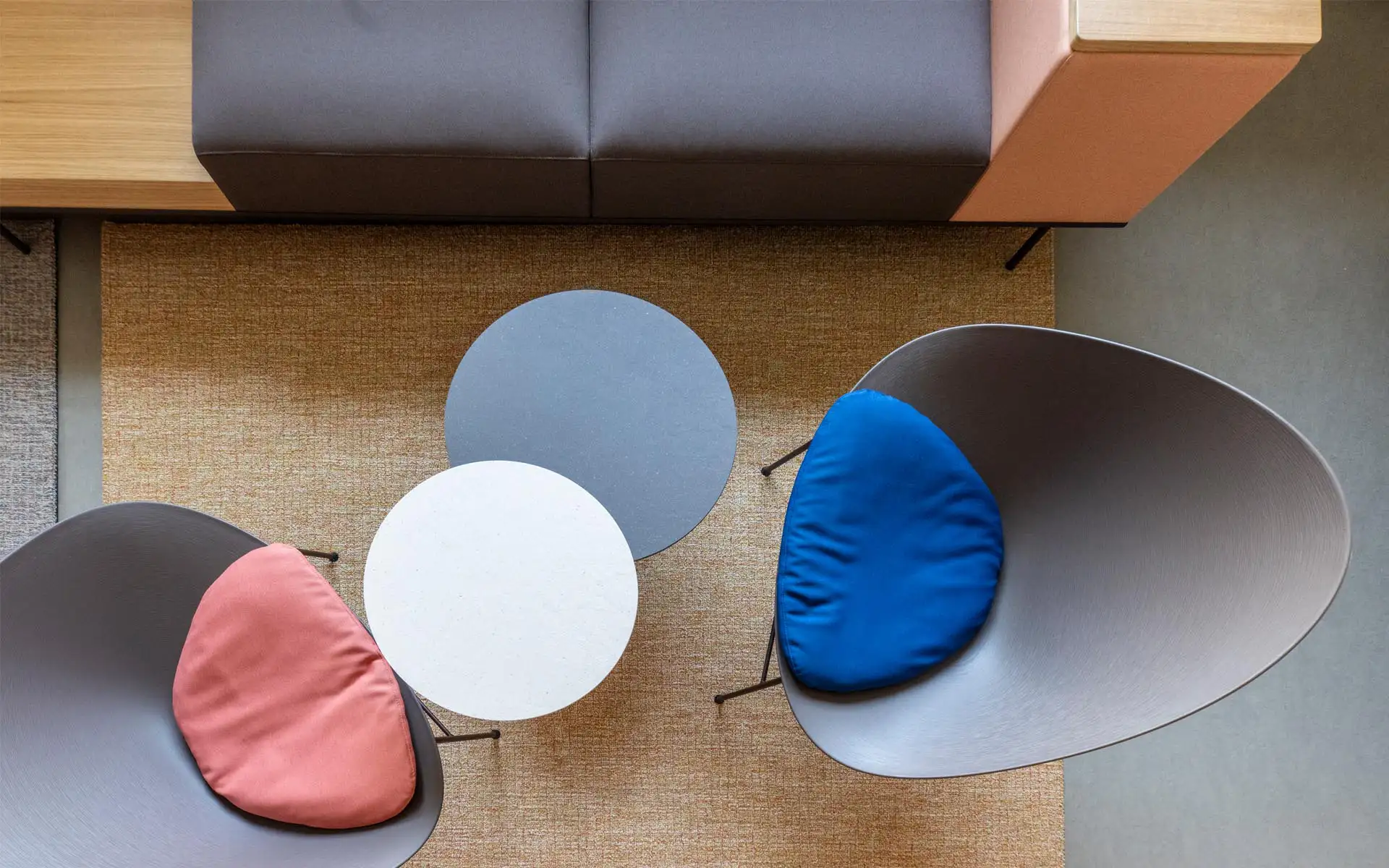 Detail Draufsicht: runde Tische, Sitzschalen mit farbigen Kissen