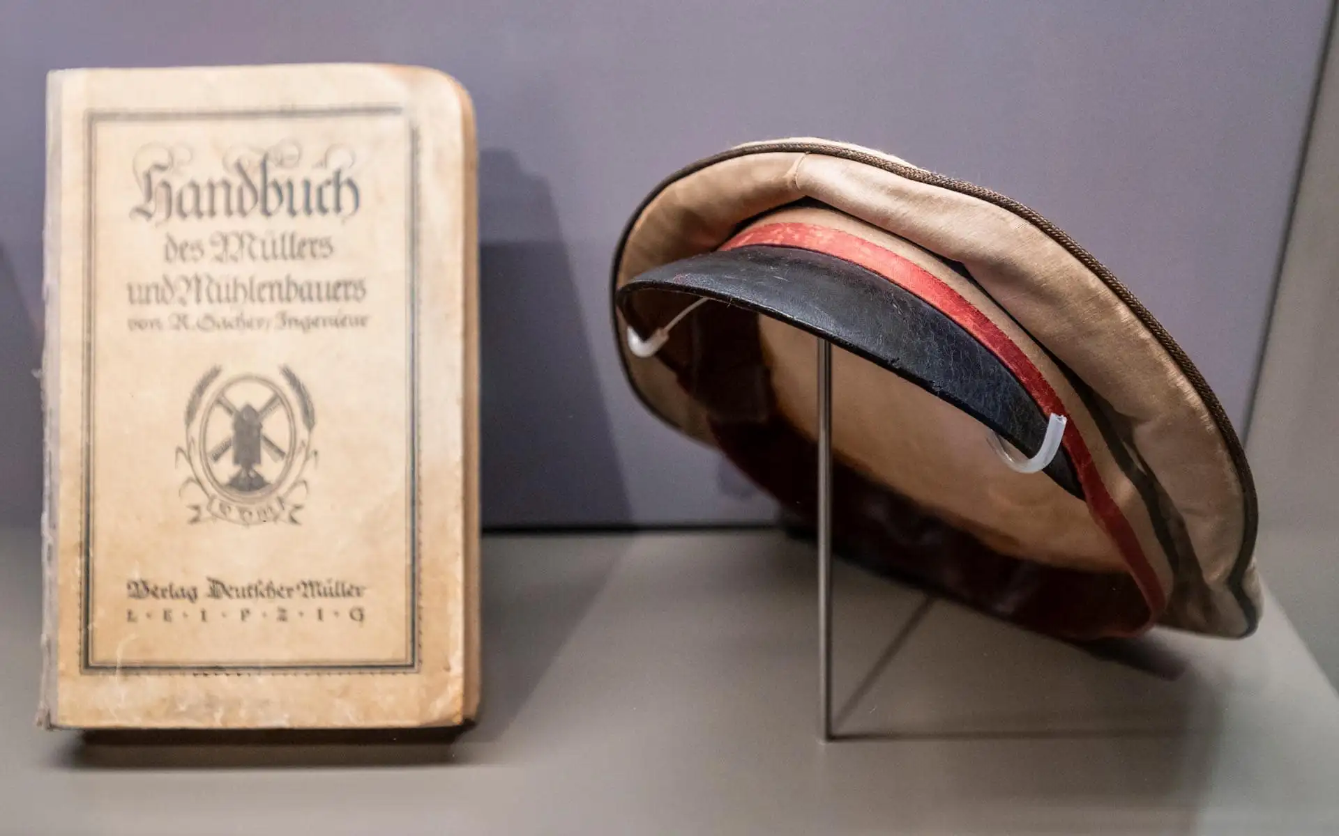 Moderne Cafétheke mit türkisfarbener Fliesenfront, heller Arbeitsfläche und skulpturalen Pendelleuchten aus Holz.