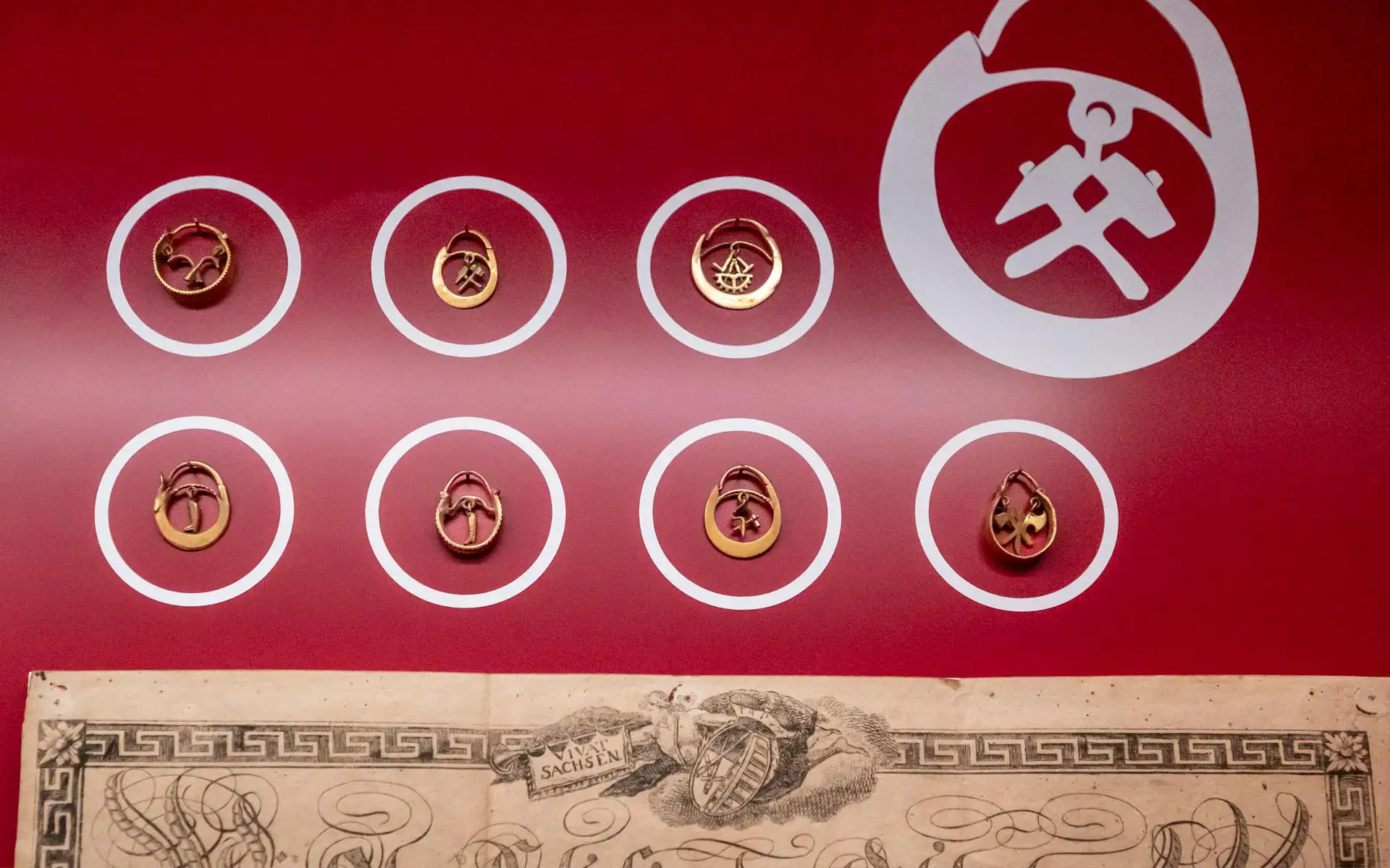 Offener Gastraum mit hoher Decke, mehreren hölzernen Pendelleuchten und klar gegliederter Thekenzone.