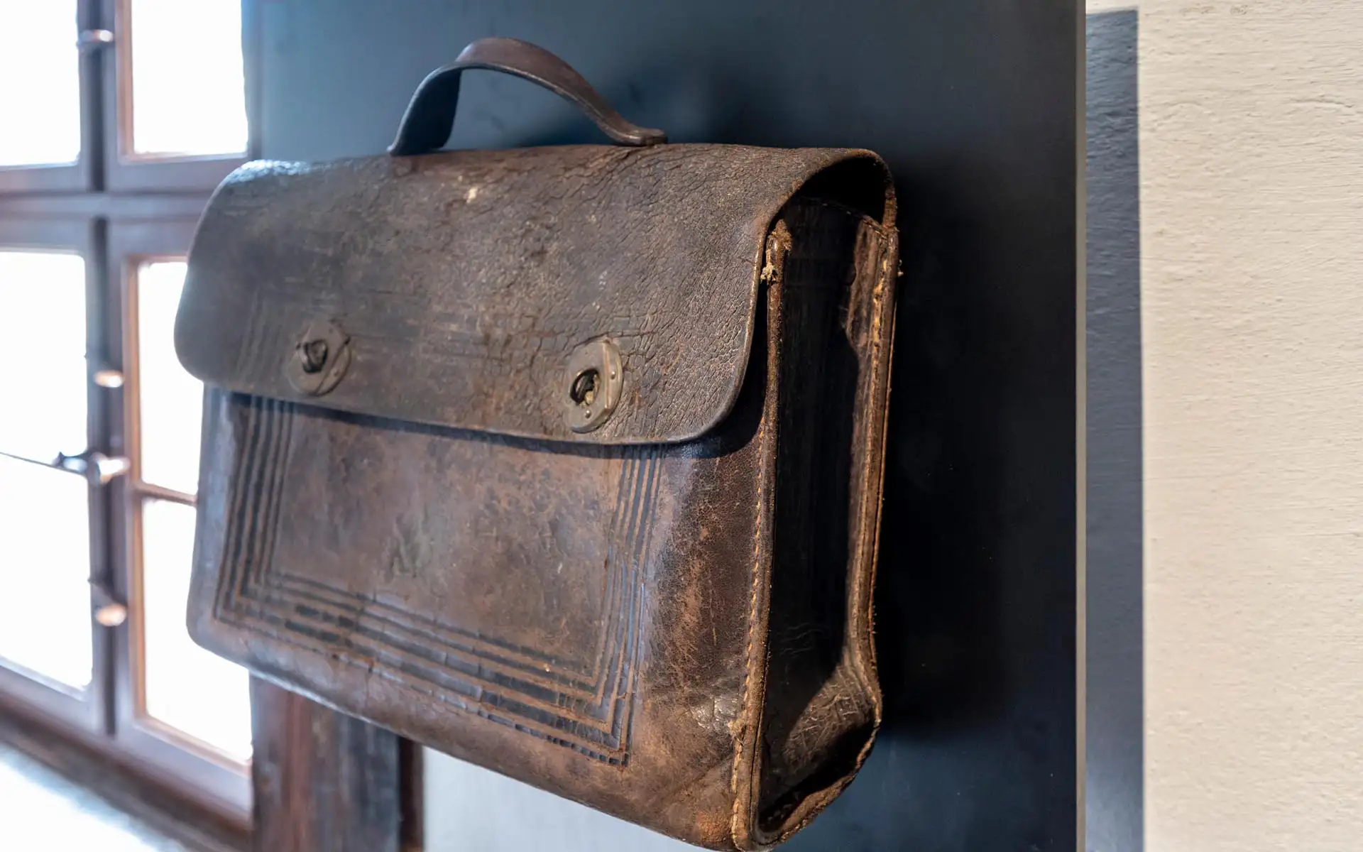 Offener Gastraum mit hoher Decke, mehreren hölzernen Pendelleuchten und klar gegliederter Thekenzone.